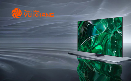 An OLED TV is displaying a green graphic on its screen while floating on top of a gray surface.